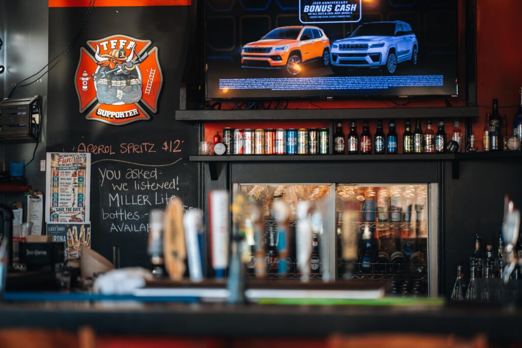 Television, drinks fridge and beer taps behind the bar