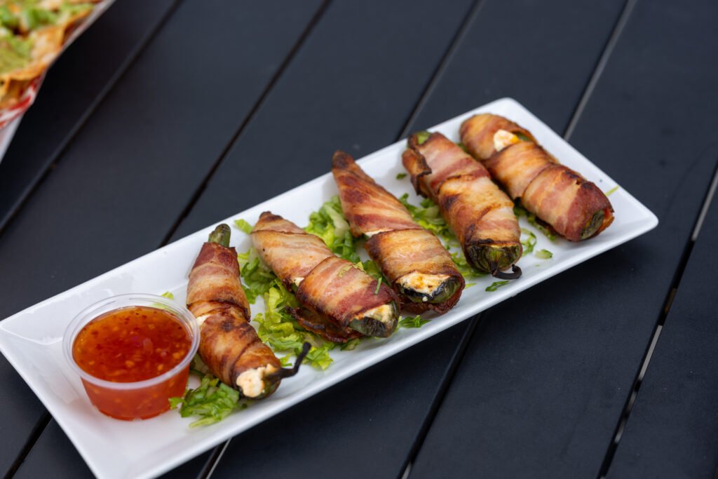 Bacon-wrapped jalapeno poppers served with dipping sauce