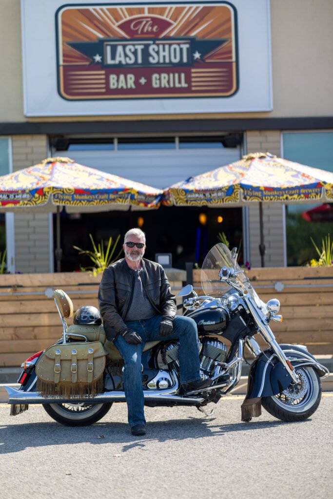 Gary beside a motorcycle outside The Last Shot
