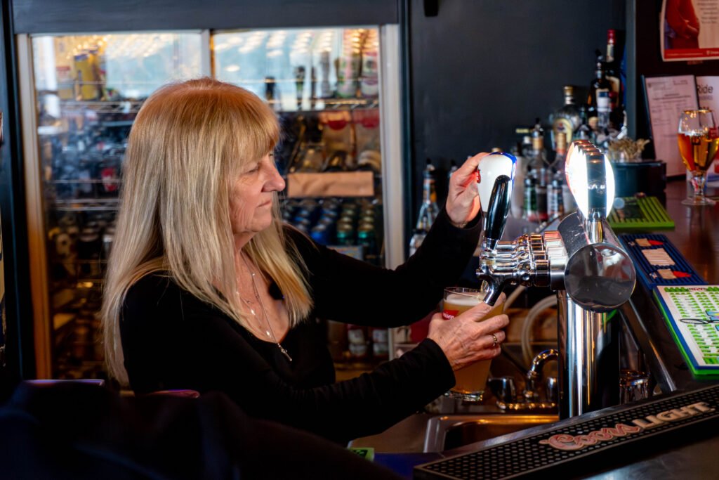 Lori pouring a draft beer at the bar