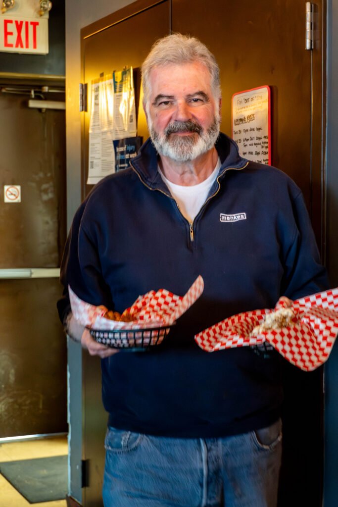 Gary carrying two food baskets inside the pub