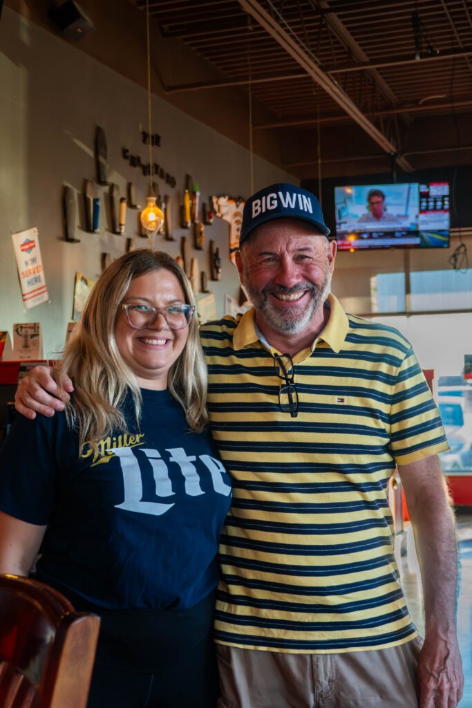Two patrons smiling together inside the pub