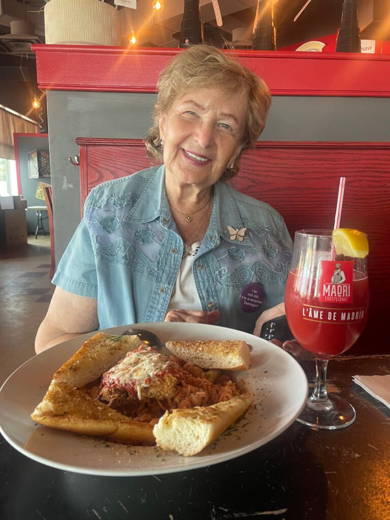 Patron smiling with a plate of food and a drink