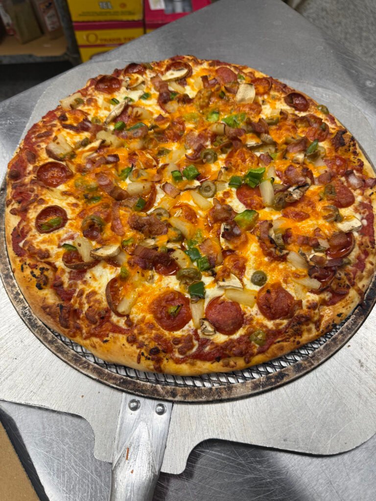 Whole pizza with assorted toppings on a metal serving tray