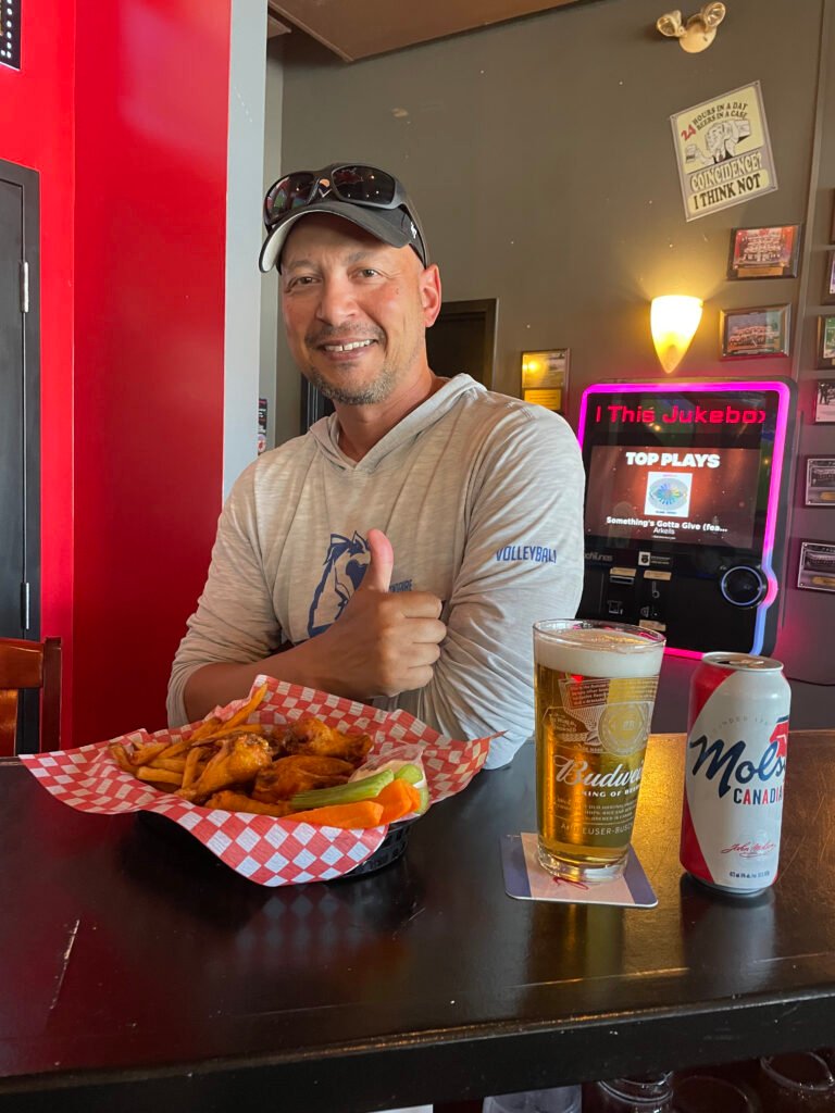 Patron giving a thumbs-up beside a basket of food at the bar